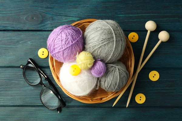 Ahşap arka planda iplik topları olan örgü konsepti.