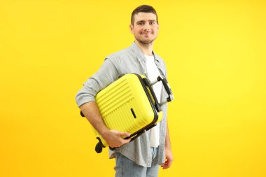Sarı arka planda genç bir adamla seyahat konsepti.