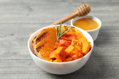 Gri desenli arka planda fırında balkabağı, bal ve balık..