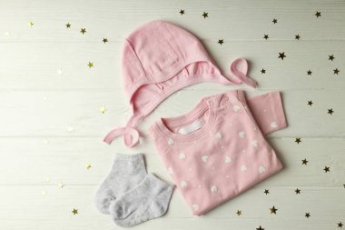 Beyaz ahşap arka planda kadın bebek kıyafetleri kavramı.