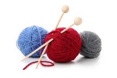 Örgü iğneli çok renkli iplik topları, beyaz arka planda izole edilmiş..