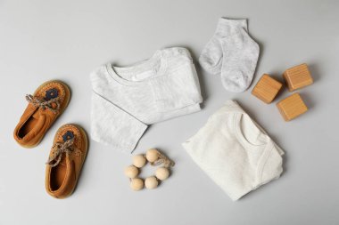 Açık gri arka planda erkek bebek kıyafetleri kavramı.