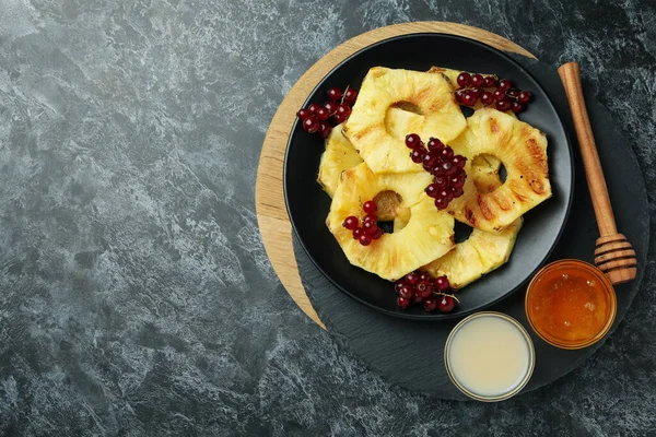 Siyah dumanlı arka planda ızgara ananas ile lezzetli yemek kavramı.