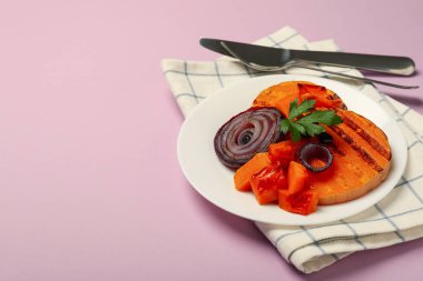 Lezzetli yemek kavramı ve menekşe arkaplanda fırında balkabağı..