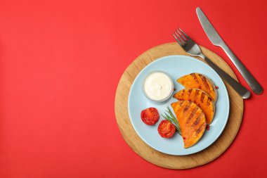 Kırmızı arka planda fırında balkabağı ile lezzetli yemek kavramı.