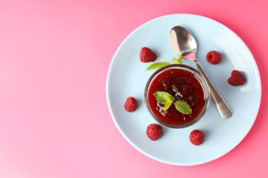 Pembe arka planda ahududu reçeli ile lezzetli yemek kavramı