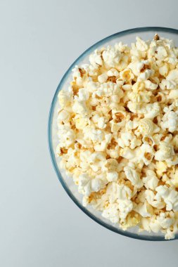 Açık gri arka planda patlamış mısırlı cam kase.