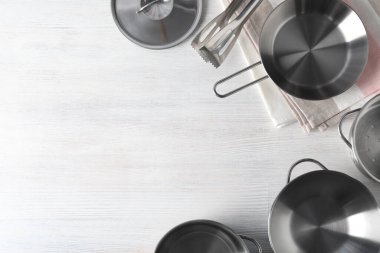 Beyaz ahşap zemin üzerinde mutfak gereçleri, üst görünüm.