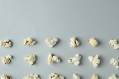 Açık gri arka planda patlamış mısırla yatıyordu.