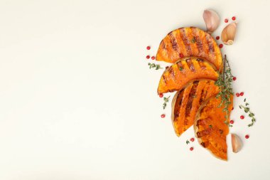 Beyaz arka planda lezzetli fırında balkabağı ve baharatlar.