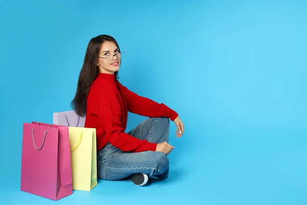 Menina Com Sacos Papel Multicoloridos Fundo Azul — Fotografia de Stock