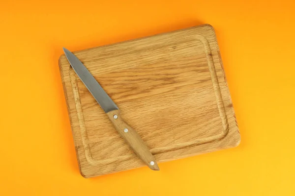 Planche Découper Avec Couteau Sur Fond Orange — Photo
