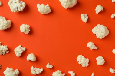 Turuncu arka planda karnabahar dilimleri olan düz bir kompozisyon.