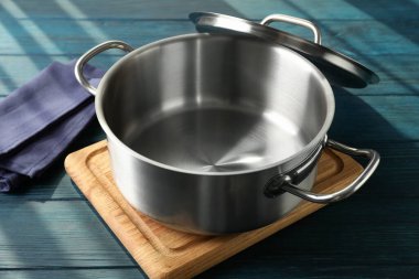 Tahta kesme tahtasındaki boş metal tencere..