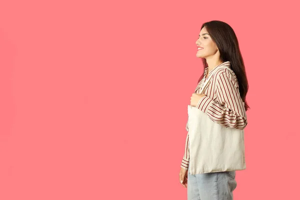 魅力的な女の子はピンクの背景に綿の袋を保持しています テキストのためのスペース — ストック写真