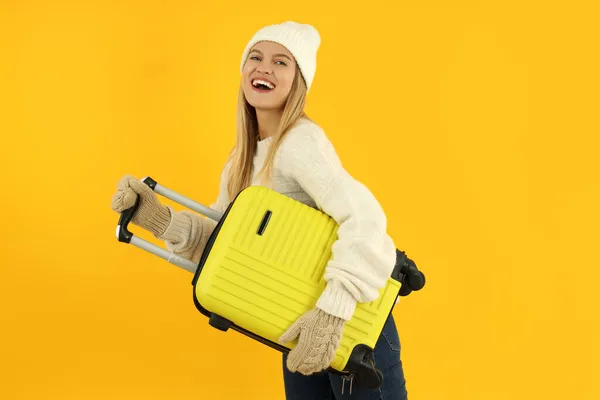 魅力的な女の子で冬服で荷物バッグで黄色の背景 — ストック写真