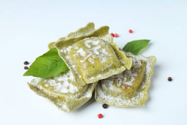 Beyaz arka planda baharatlı çiğ ravioli.