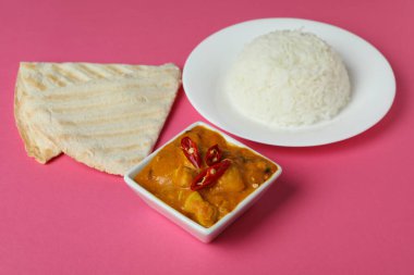 Pembe arka planda malzemeleri olan tavuk tikka.