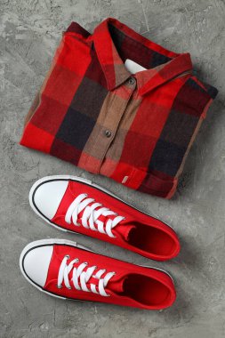 Gri arkaplanda kırmızı spor ayakkabılar ve gömlek
