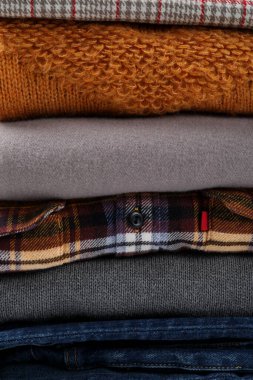 Arka planda bir yığın kışlık kıyafet var..