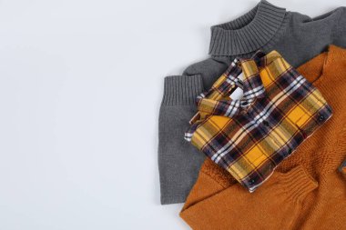 Beyaz arkaplanda gömlekli süveterler, metin için boşluk.