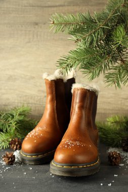 Kışlık giysi kavramı, üzerinde çizmeler olan siyah tahta masa..