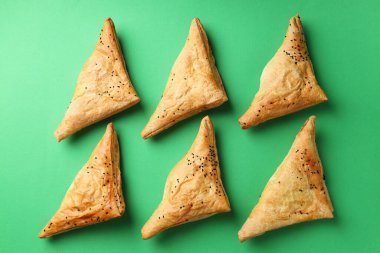 Yeşil arka planda samsa ile düz konum