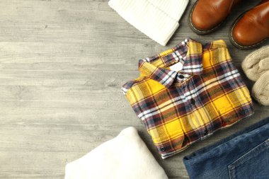 Gri ahşap masadaki kışlık kıyafet kavramı.