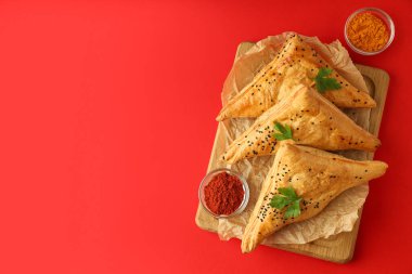 Kırmızı zemin üzerinde samsa olan lezzetli yemek kavramı