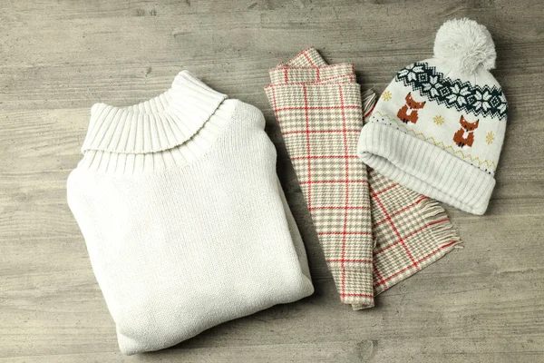 Gri ahşap masadaki kışlık kıyafet kavramı.