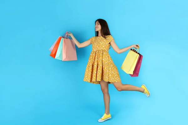 Привлекательная Девушка Разноцветными Бумажными Пакетами Синем Фоне — стоковое фото