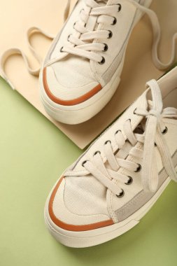 İki ton arkaplanda bir çift bej spor ayakkabı