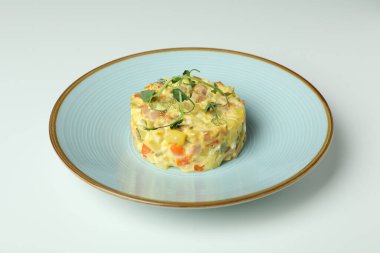 Beyaz arka planda Olivier salatası ile tabak