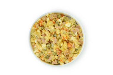 Beyaz arka planda bir kase Olivier salatası.