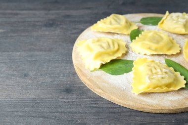 Koyu ahşap zemin üzerinde çiğ ravioli olan tahta.