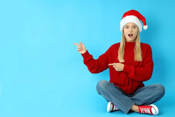 Mavi Arka Planda Noel Baba Şapkalı Çekici Kız Mesaj Için — Stok fotoğraf