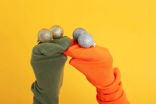 Sock puppets with baubles on yellow background