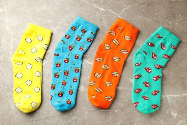 Funny bright socks on gray textured background