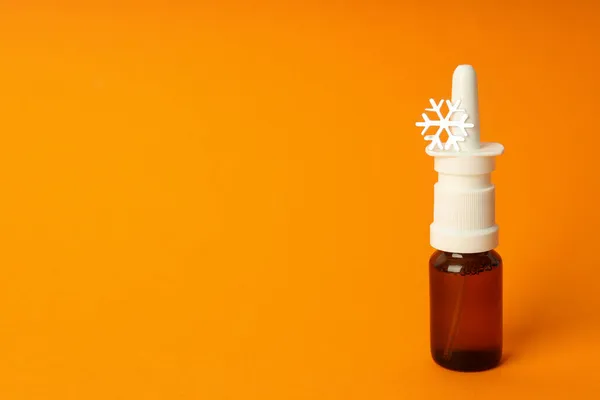 Leere Flasche Nasenspray Mit Dekorativer Schneeflocke Auf Orangenem Hintergrund — Stockfoto