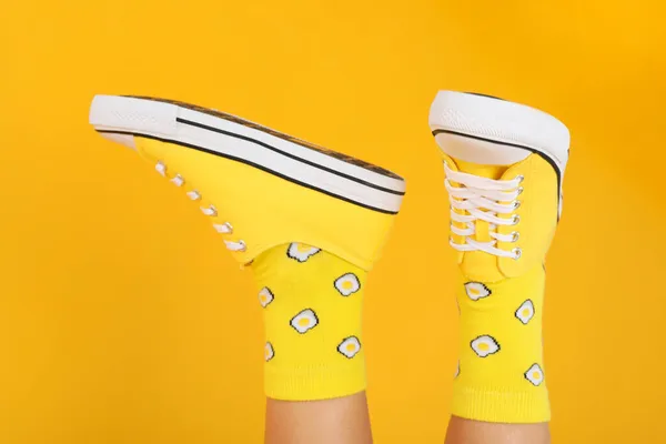 Jambes Féminines Chaussettes Avec Œufs Baskets Sur Fond Jaune — Photo