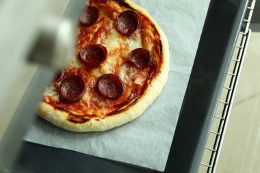 Fırında salamlı pizza pişirme kavramı.