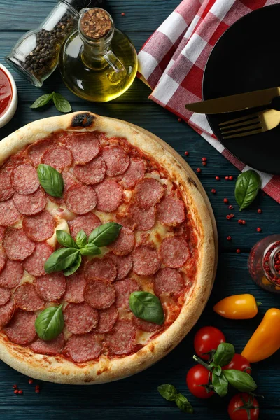 Tahta masada salamlı pizza ile lezzetli yemek kavramı