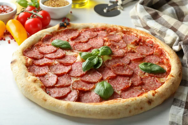 Beyaz ahşap arka planda salamlı pizza ile lezzetli yemek kavramı