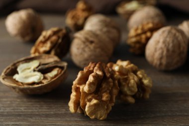 Ahşap arka planda mutfak havlusu olan cevizler.