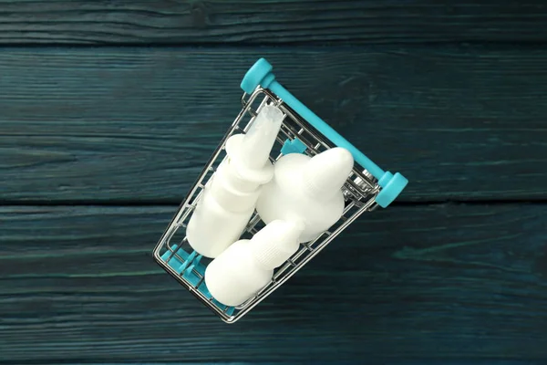 Toko Troli Dengan Botol Semprotan Hidung Pada Latar Belakang Kayu — Stok Foto