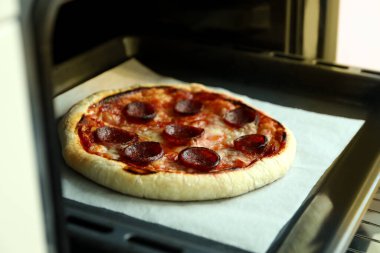Fırında salamlı pizza pişirme kavramı.