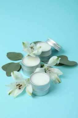 Mavi arka planda eko dudak kremi ve çiçekler