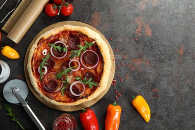 Lezzetli yemek kavramı ve siyah masada salamlı pizza.