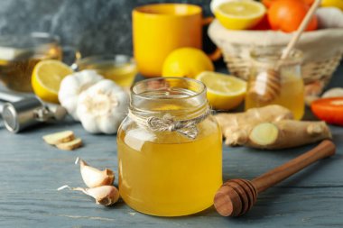 Tedavi anlayışı, ballı soğuk algınlığı ve gri ahşap masada sarımsak.