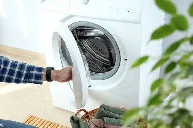 Beyaz duvara karşı çamaşır makinesiyle ev işi kavramı